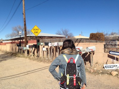 Holly pausing in her footsteps to look at cluster dwelling in Santa Fe, New Mexico